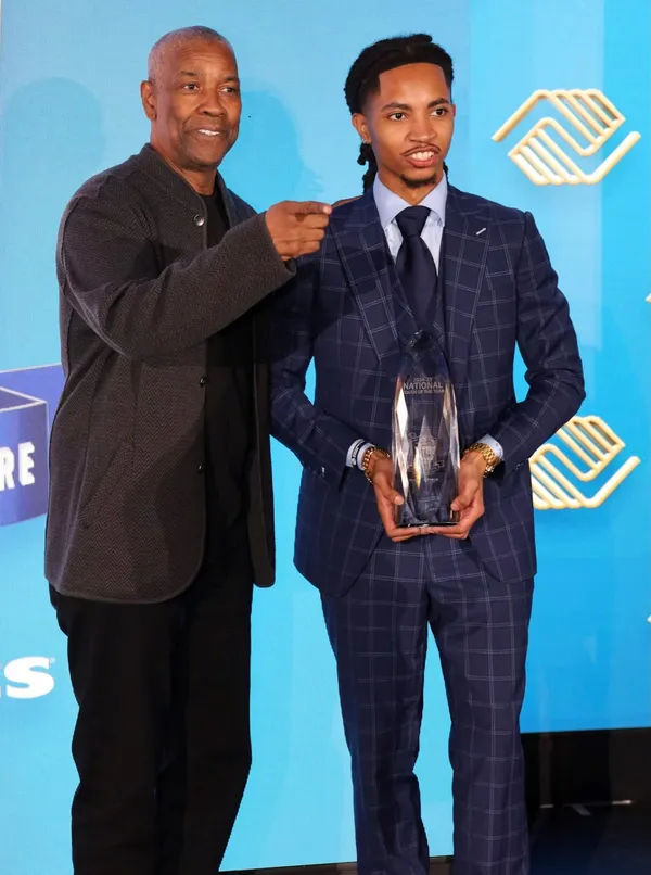Nico Flowers, right, of Jacksonville holds the Boys & Girls Clubs of America's 2024 National Youth of the Year award that was presented to him by actor and director Denzel Washington, a club alumnus. Provided By Boys & Girls Clubs Of Northeast Florida